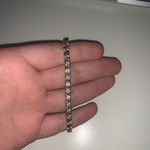 Gold bracelet with diamonds in the middle.